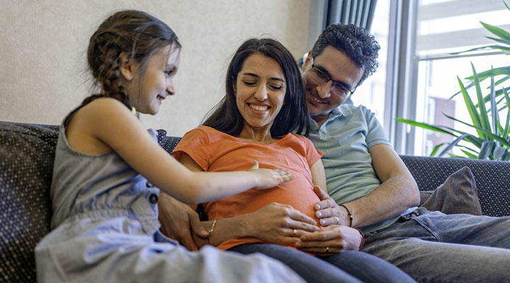 اهمیت آموزش مسائل جنسی به کودکان + راهنمای آموزش در سنین مختلف 24 آموزش مسائل جنسی به کودکان ـ پدر، مادر و کودکی که با لمس شکم برآمده مادرش کنجکاوی خود را نشان میدهد